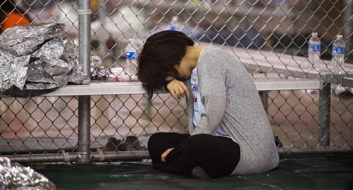 A female minor rests her head on a bench in the US Border Patrol Central Processing Center in McAllen, Texas on August 12, 2019.