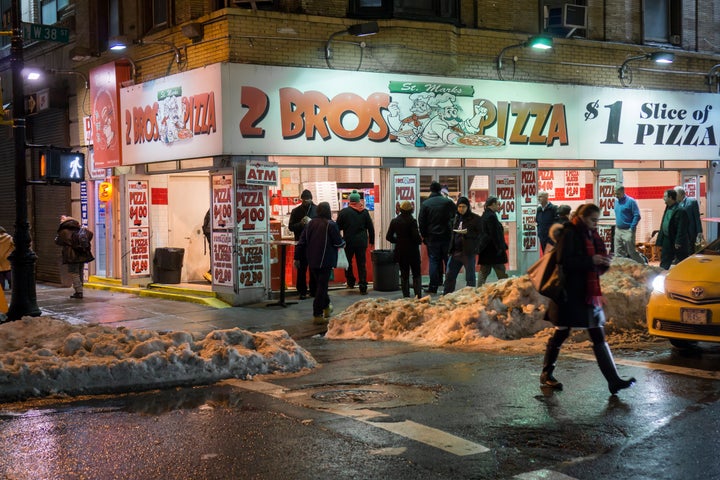 Pizza lovers line up at a 2 Bros. Pizza store in Midtown Manhattan.