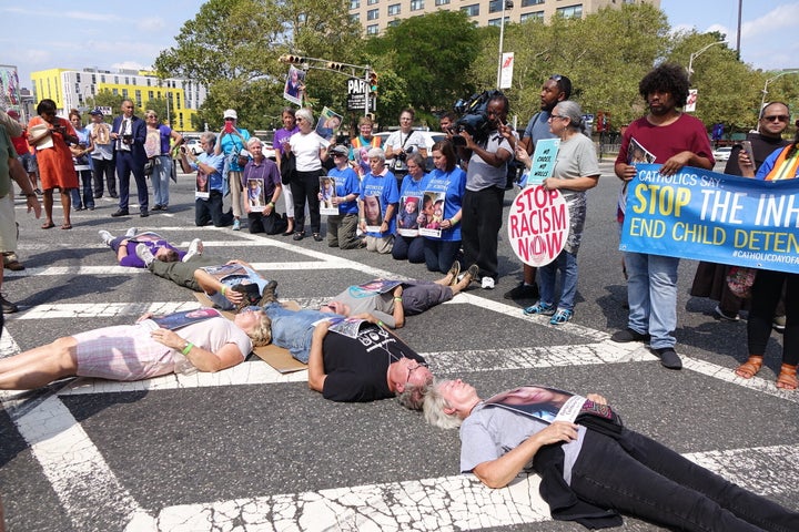 Catholic protesters form the shape of the cross and block a road outside Newark's Peter Rodino Federal Building, hoping to raise awareness of ICE's detention policies.