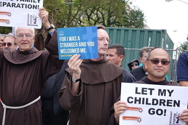 Protesters hold signs during a demonstration in Newark against the U.S. government's detention of migrant families and children.