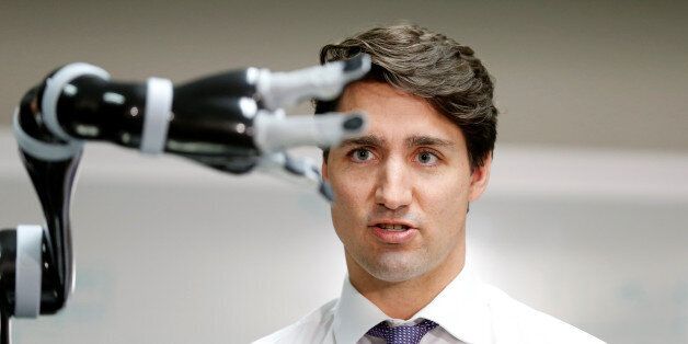 Canadian Prime Minister Justin Trudeau controls a robotic arm as he takes part in a robotics demonstration...