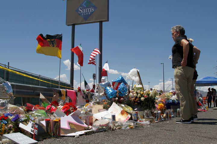 In this Aug. 12, 2019 photo, mourners visit the makeshift memorial near the Walmart in El Paso, Texas, where 22 people were killed in a mass shooting that police are investigating as a terrorist attack targeting Latinos. The flags show the nationalities of those killed in the attack, including a German man who lived in nearby Ciudad Juarez, Mexico. On Thursday, Aug. 22, 2019, Walmart said it plans to reopen the El Paso store where 22 people were killed in a mass shooting, but the entire interior of the building will first be rebuilt. 