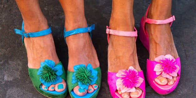 Four pretty pedicured feet in flowery sandals,