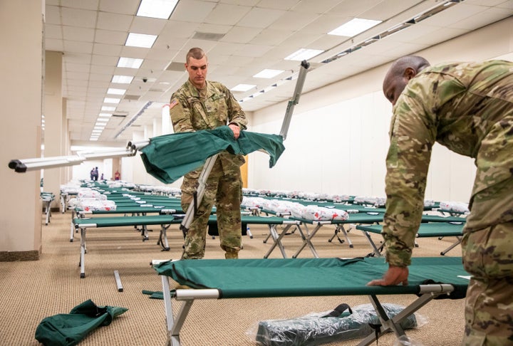US Army National Guard Pvt. Christopher Zambuto, left, and Specialist Jermaris Hamilton assemble cots in a shelter for Hurricane Dorian evacuees inside the old Sears location at Northgate Mall, on Wednesday, Sep. 4, 2019, in Durham, NC. (Casey Toth/The News & Observer via AP)