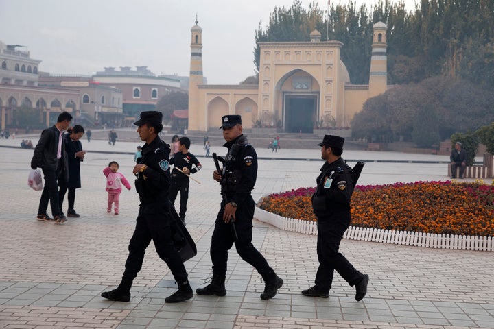 In this Nov. 4, 2017 photo, Uighur security personnel patrol near the Id Kah Mosque in Kashgar in western China's Xinjiang re