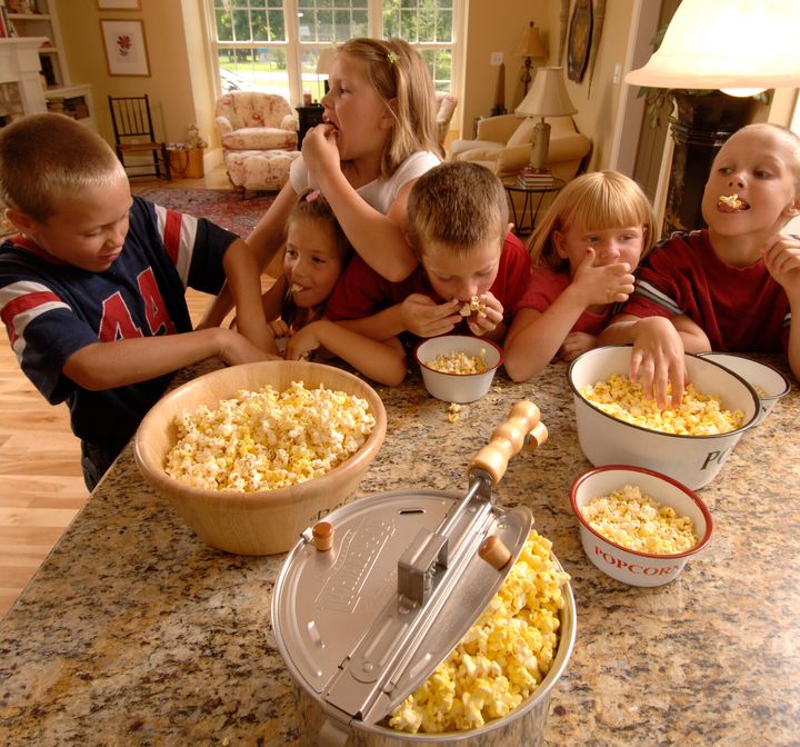 A group of children devour their popcorn in a promotional image used by Whirley Pop.