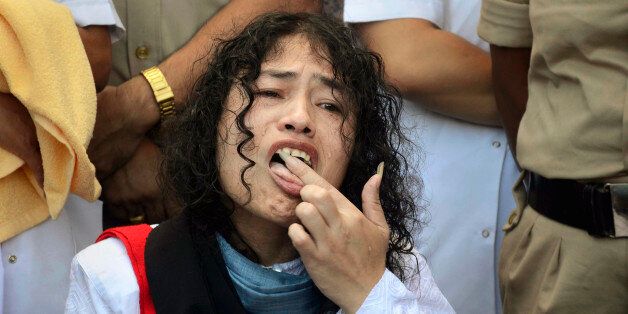 Indian political activist Irom Sharmila licks honey from her hand to break her fast in Imphal, north-eastern...