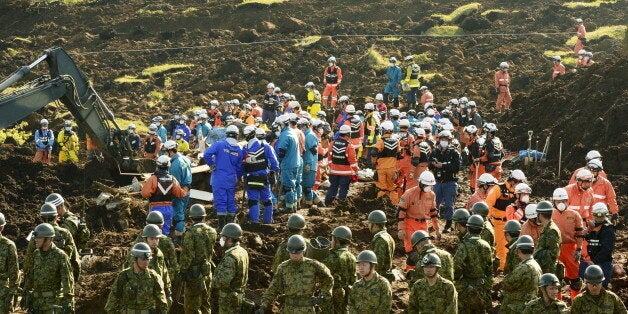 Rescue workers and Japan Ground Self-Defense Force soldiers conduct search and rescue operations at site...