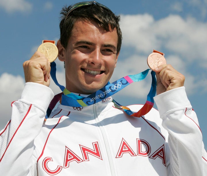 Adam van Koeverden holds up a gold and bronze medals at the Summer Olympics in Schinias, Greece, on Aug. 28, 2004.