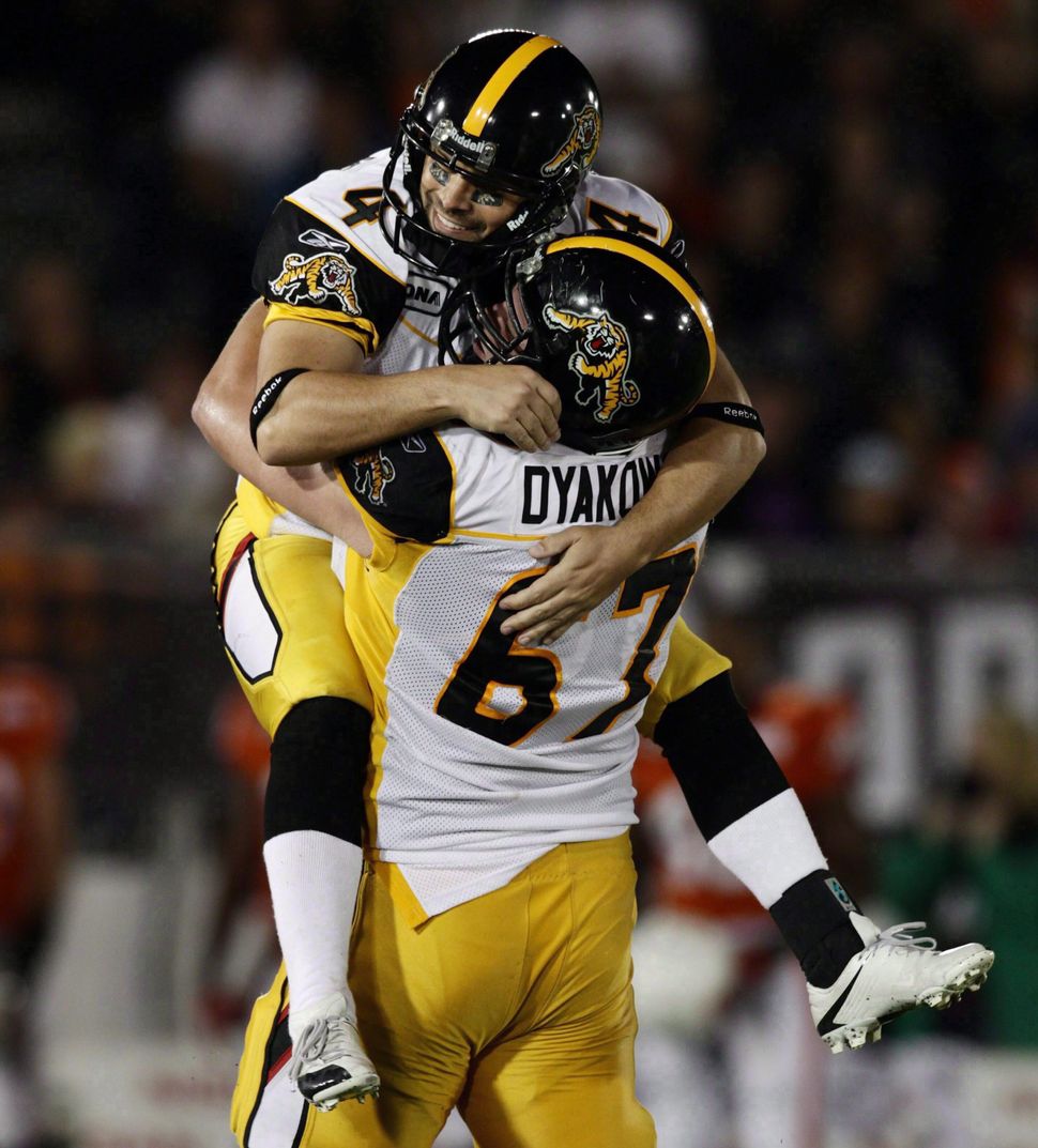 Peter Dyakowski lifts kicker Sandro DeAngelis after a field goal against the B.C. Lions in Vancouver on Sept. 18, 2010.