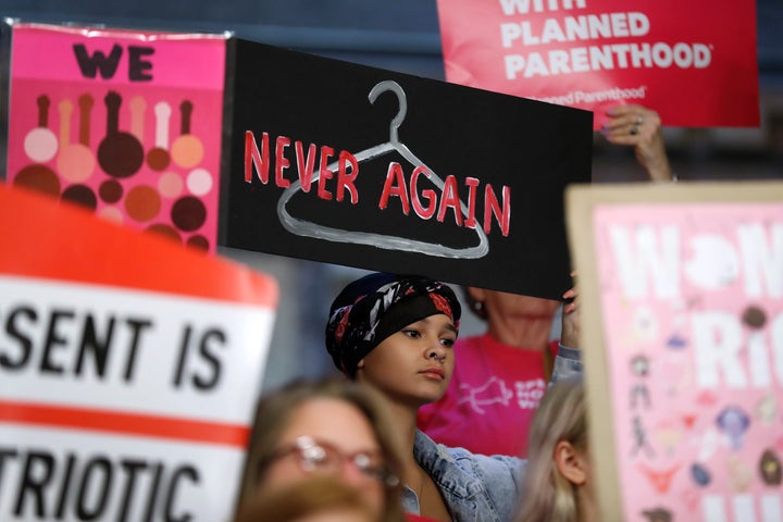 August Mulvihill of Norwalk, Iowa holds a sign depicting a wire hanger during a rally to protest recent abortion bans put forward in several state legislatures at the Statehouse in Des Moines, Iowa, on May 21, 2019.