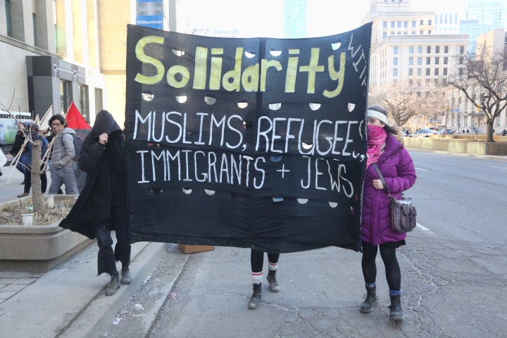 Protestors carry a large banner during a rally held in Toronto March 23, 2019.