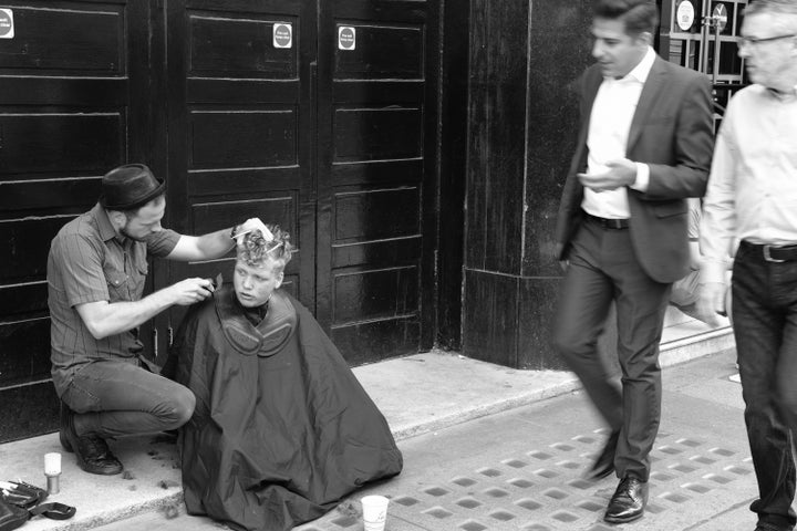 "A kind barber gives a free haircut to a homeless man outside Victoria station."