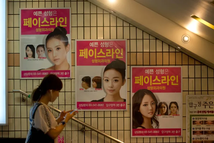 Advertisements for plastic surgery clinics are displayed at a subway station in Seoul.