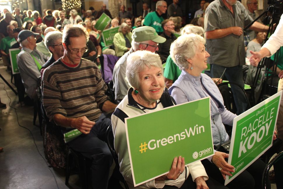 A supporter holds a sign during a Green Party rally in Victoria on Sept. 9. 