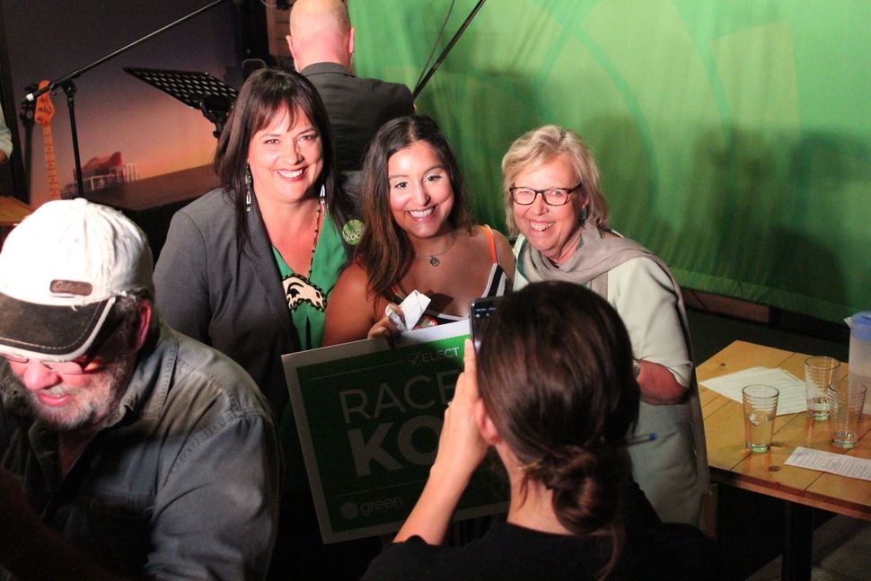Green Party leader Elizabeth May and Victoria candidate Racelle Kooy pose with supporters following a rally in Victoria. 