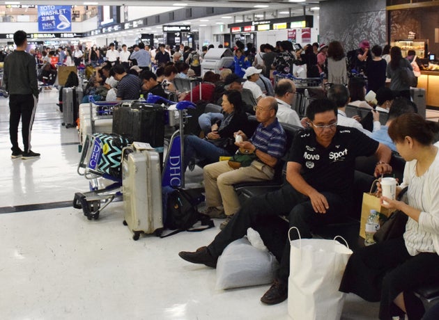 ロビーで一夜を明かし、電車やバスの出発を待つ利用客ら=9月10日、成田空港