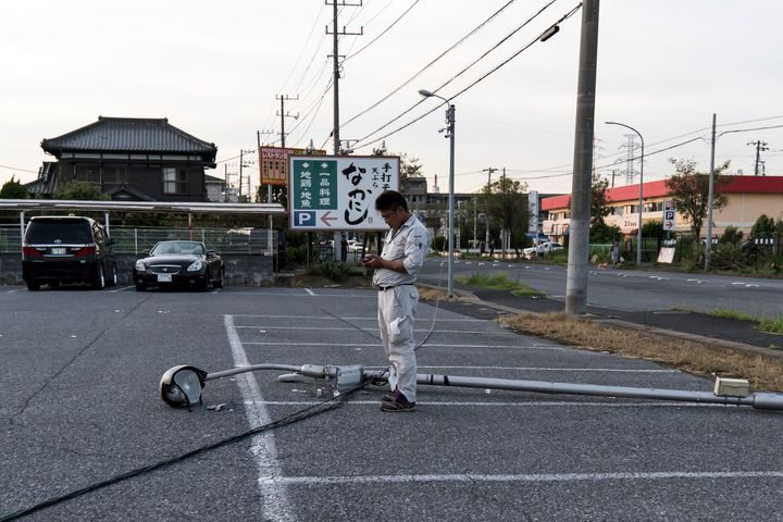 ICHIHARA, JAPAN - SEPTEMBER 09: A man stands next to a damaged street light following the passage of Typhoon Faxai on September 09, 2019 in Ichihara, Japan. The powerful typhoon hit the Kanto region early Monday morning causing blackouts and transport disruption in the metropolitan area. (Photo by Tomohiro Ohsumi/Getty Images)