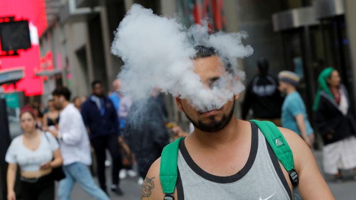 A man uses a vape as he walks on Broadway in New York City, U.S., September 9, 2019. REUTERS/Andrew Kelly