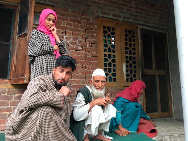 In this Monday, Aug. 26, photo, A Kashmiri man Mohammed Abdullah, center, sits with family members at...