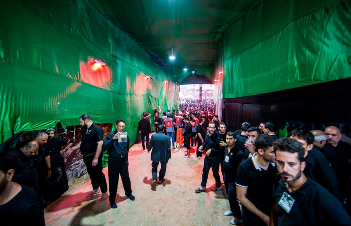 Shiite Muslim pilgrims walk through the the Bab al-Raja gate of the courtyard of the Imam Hussein shrine in the central Iraqi holy city of Karbala on September 11, 2019.