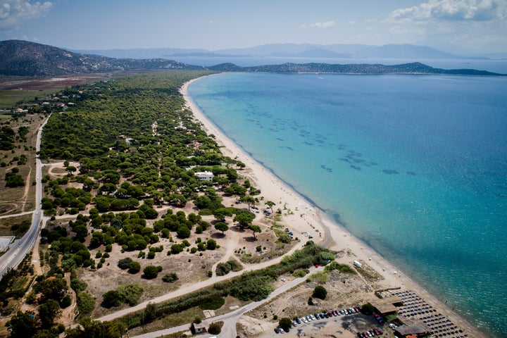 Φωτογραφία του 2018. Διακρίνεται ένα από τα εστιατόρια/αναψυκτήρια με τις ξαπλώστρες σε ανάπτυξη, στην παραλία του Μαραθώνα, δίπλα στο δάσος του Σχινιά.