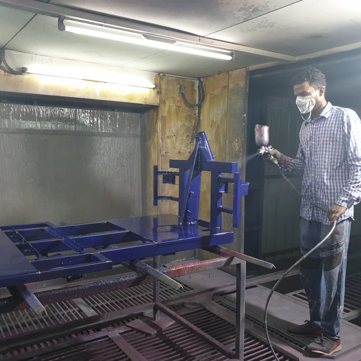 A worker painting the chassis of an e-rickshaw at an electric vehicle manufacturing company in Zirakpur, Punjab.