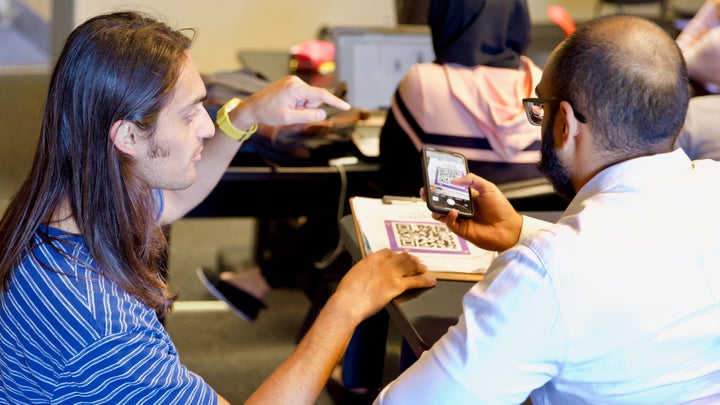Kyle Visvanathan, left, helps a student scan Future Majority's QR code, directing him to educational, non-partisan resources about the upcoming election.