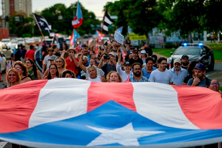 People march in protest in San Juan on July 29, 2019, against the next-in-line for Puerto Rico's governorship, Wanda Vázquez.