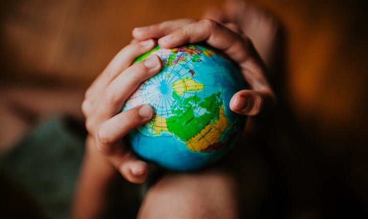 Child's hands holding a globe, space for copy.（イメージ写真）