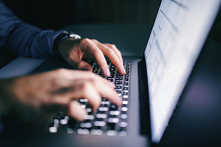 Close up of hands typing on laptop. Night work concept.（イメージ写真）