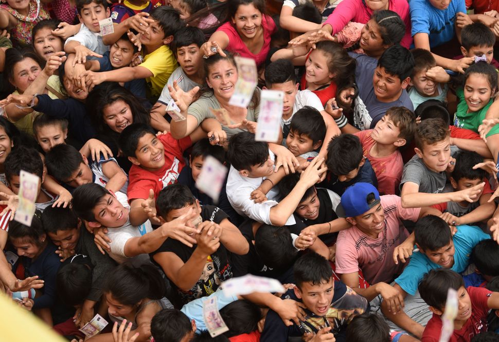Παιδιά προσπαθούν να πιάσουν χαρτονομίσματα που πετάνε καθολικοί από τον τρούλο της εκκλησία, σε ένδειξη ευγνωμοσύνης για τις χάρες που έλαβαν από την Παναγία, στο πλαίσιο μίας παραδοσιακής ετήσιας τελετής, στο Γκουαραμπάρε, στα νοτιοανατολικά της Ασουνσιόν, στην Παραγουάη, στις 7 Σεπτεμβρίου.