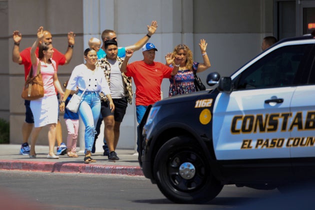 Shoppers exit with their hands up after a mass shooting at a Walmart in El Paso, Texas, on Aug. 3. The...