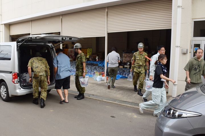 町役場の給水所で6リットル入りの水を受け取り、自家用車に積み込む住民ら＝13日、千葉県多古町