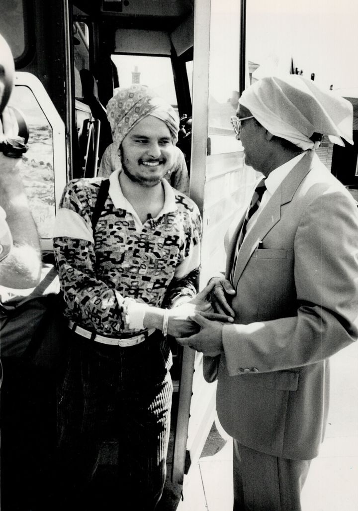 Welcome hand: In 1987, the first of 47 Sikh refugees to step off the bus after arriving in Metro is greeted by a representative of the Sri Guri Singh Sabha temple on Old Weston Rd. near St. Clair Ave. following a 18 1/2-hour trip from Halifax. No one was allowed to get on or off en route. (Photo by Andrew Stawicki/Toronto Star via Getty Images)