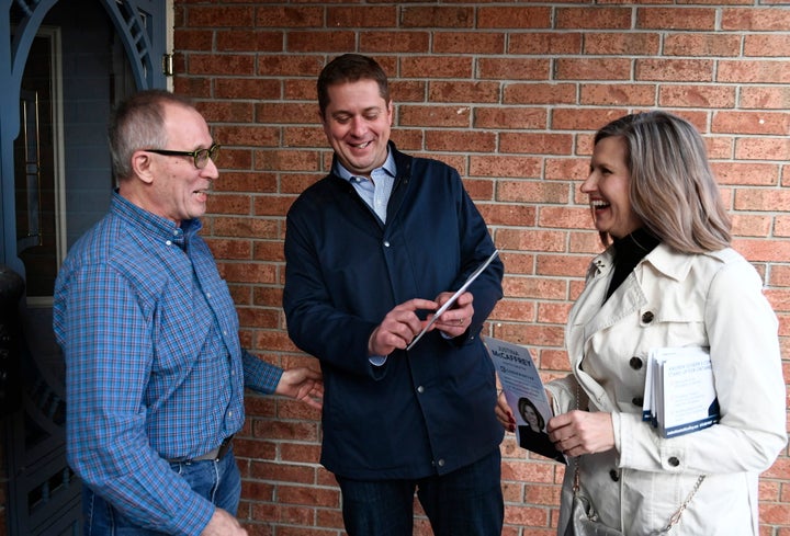 Conservative Leader Andrew Scheer speaks to a resident with Kanata Carleton candidate Justina McCaffrey, right, during a door knocking event in the Kanata suburb of Ottawa on April 25, 2019.