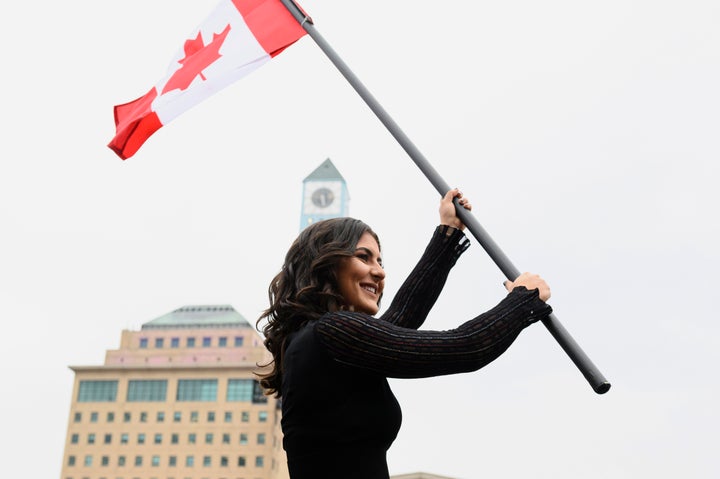Canadian tennis star and U.S. Open winner Bianca Andreescu holds up a Canadian flag at a rally for her in Mississauga, Ont. on Sept. 15, 2019.