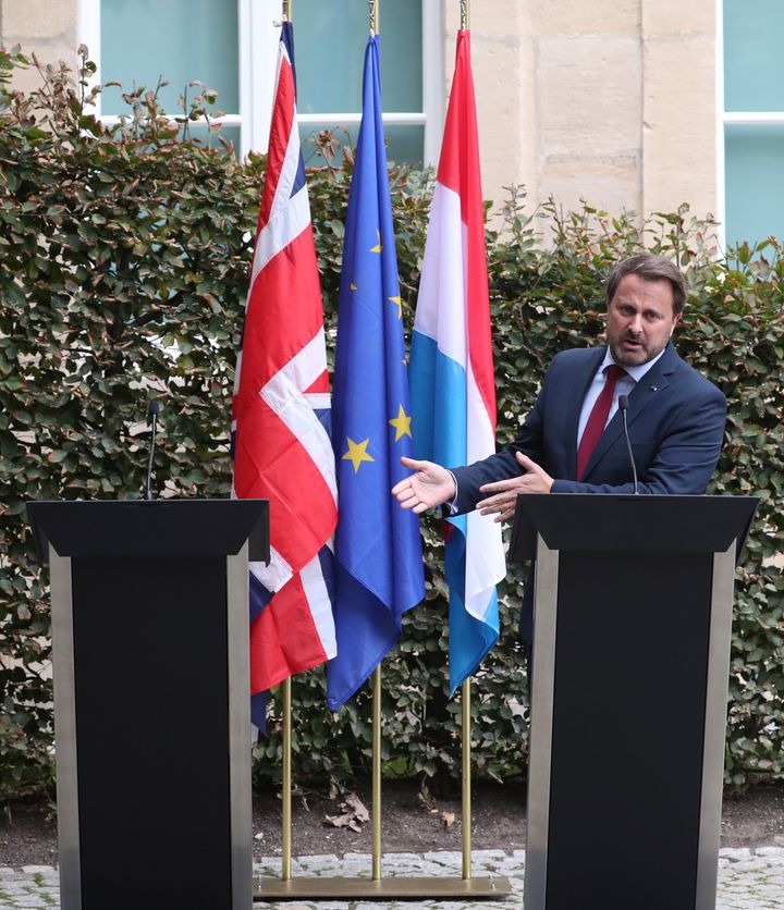 Luxembourg's PM Xavier Bettel gestures towards Boris Johnson's empty podium after his pulled out of a press conference
