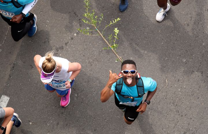 Activist and treegrower Siyabulela Sokomani celebrates as he approaches the final stretch of the Cape Town marathon, in South Africa September 15, 2019. He is one of a group of 20 runners participating in the marathon with saplings on their backs to promote the planting of native trees amid a nationwide push to replace invasive species with indigenous ones to cope with drought and climate change. REUTERS/Mike Hutchings