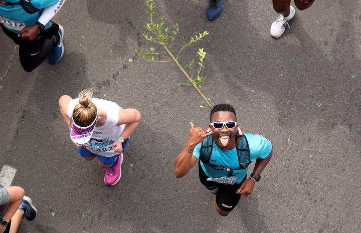 Activist and treegrower Siyabulela Sokomani celebrates as he approaches the final stretch of the Cape Town marathon, in South Africa September 15, 2019. He is one of a group of 20 runners participating in the marathon with saplings on their backs to promote the planting of native trees amid a nationwide push to replace invasive species with indigenous ones to cope with drought and climate change. REUTERS/Mike Hutchings