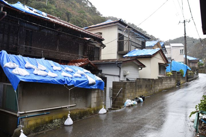 雨漏り対策のブルーシートに覆われた民家＝16日、千葉県鋸南町岩井袋