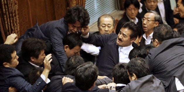 Opposition lawmakers surge toward the chairmanâs seat to protest as ruling party colleagues rush in...