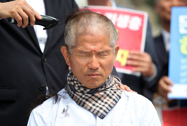 김문수 전 지사의 머리를 깎는 사람은 바리깡을 든 손만을 사용하고 있다. 바리깡을 들지 않은 손이 김 전 지사의 어깨에 얹혀져