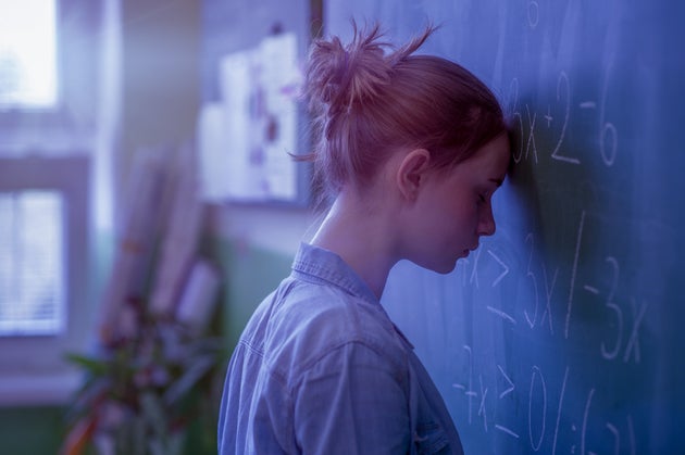 Teenager girl in math class overwhelmed by the math formula. Pressure, Education, Success concept.