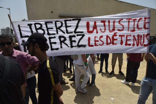 Algerians wave a banner reading in French