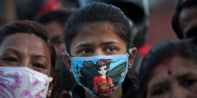 A Nepalese girl watches a rescue operation at an area that collapsed in Saturday's earthquake in Kathmandu,...
