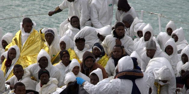 Migrants wait to disembark from an Italian Coast Guard ship after being rescued in Porto Empedocle, Sicily,...