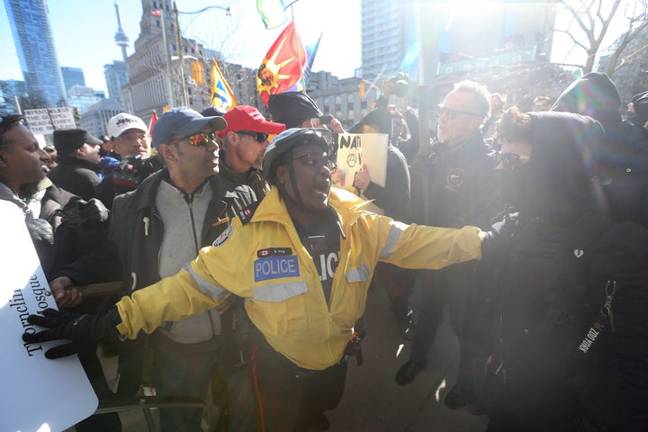 Police keep about 40 anti-Muslim protesters and several hundred counter protesters apart during a Toronto demonstration, March 23, 2019.