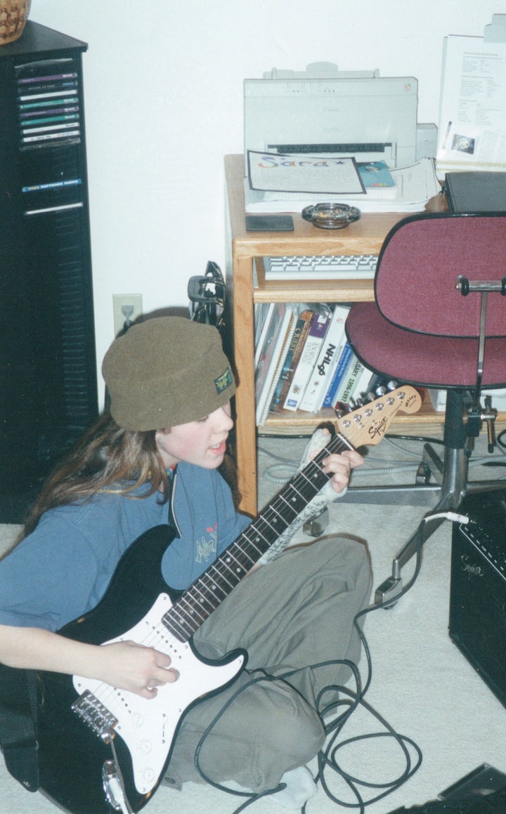 Sara playing electric guitar.