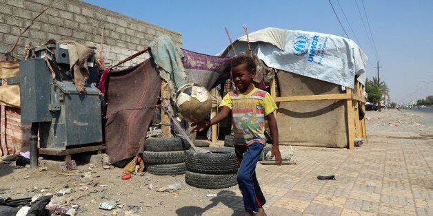 A displaced Yemeni child plays with a ball next to their makeshift shelter on a street in the Yemeni coastal city of Hodeidah on November 16, 2017. / AFP PHOTO / ABDO HYDER (Photo credit should read ABDO HYDER/AFP/Getty Images)